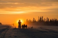 двое погонщиков на собачьих упряжках едут в лучах заходящего солнца Великие озера Канада.jpg